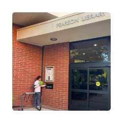 image of person using book drop outside the library